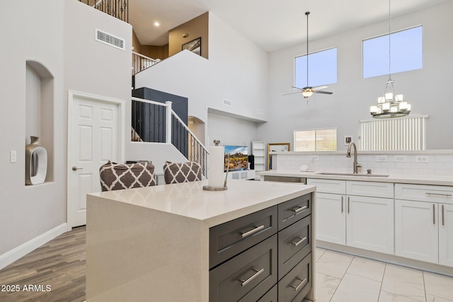 46141 W Rainbow Dr, Maricopa, AZ 85139 - kitchen with ceiling fan, a high ceiling, plenty of natural light, white cabinetry, and light countertops