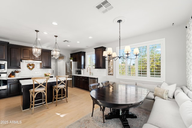 living room with visible vents, recessed lighting, plenty of natural light, and an inviting chandelier
