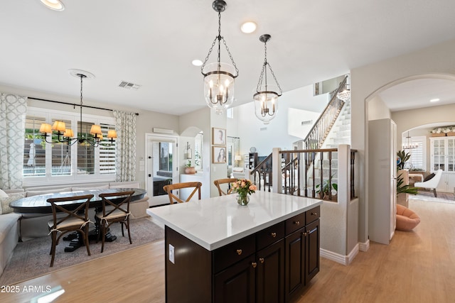 kitchen featuring visible vents, open floor plan, light wood-style flooring, and a chandelier