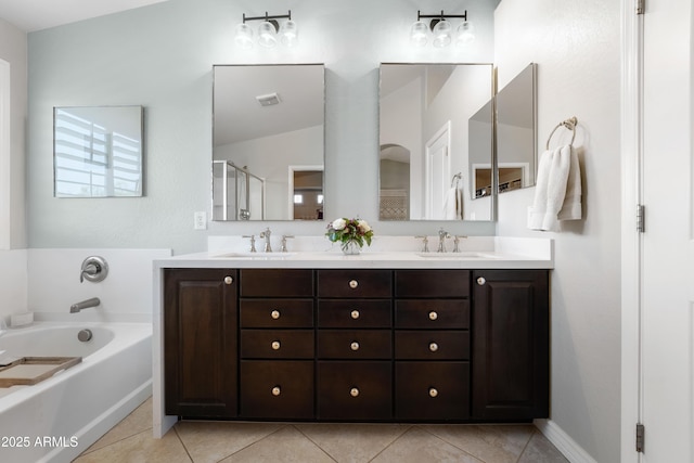 full bath featuring visible vents, double vanity, a bath, tile patterned floors, and a sink