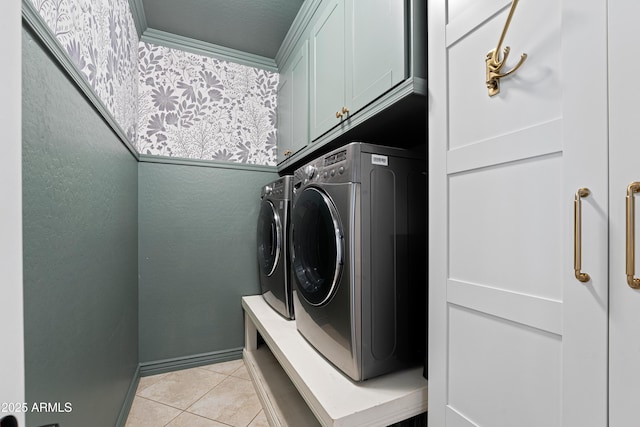 washroom with light tile patterned floors, washing machine and dryer, and cabinet space