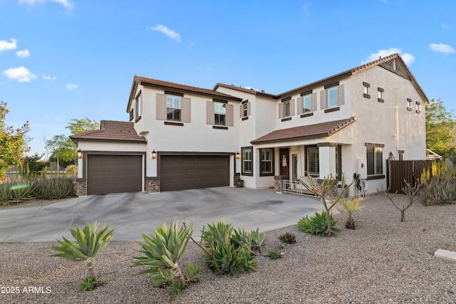 view of front of property with an attached garage, stucco siding, a tile roof, and concrete driveway