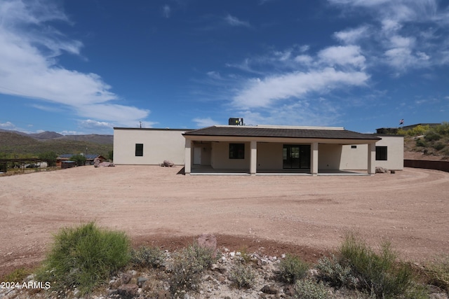 rear view of house with a patio area and a mountain view