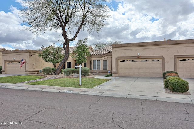 view of front of home with a tile roof, concrete driveway, a front lawn, and stucco siding