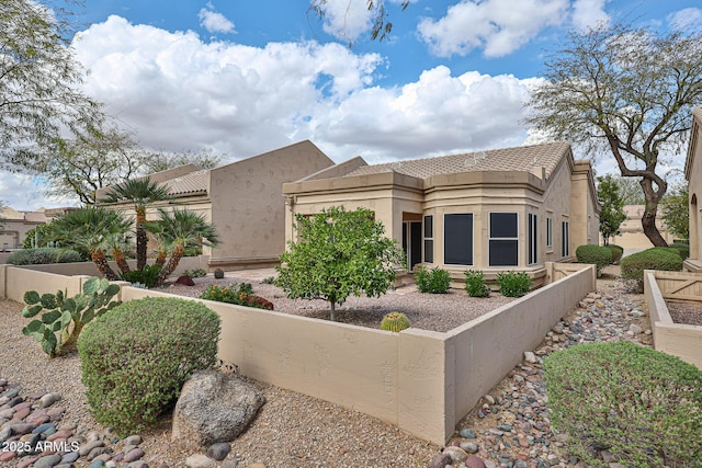 view of home's exterior featuring a tiled roof, fence, and stucco siding