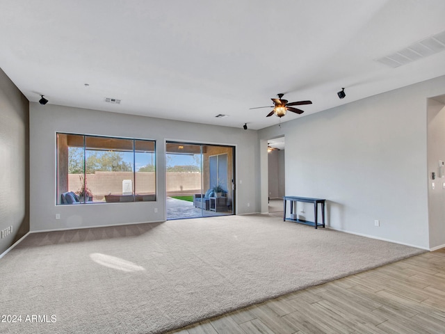 interior space with ceiling fan, visible vents, and baseboards