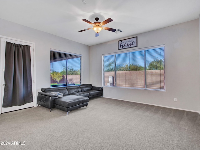 living area with carpet floors, baseboards, visible vents, and a ceiling fan