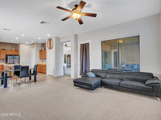 living room with ceiling fan, sink, and light hardwood / wood-style floors