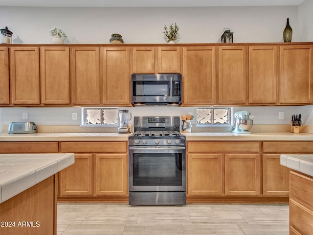 kitchen with appliances with stainless steel finishes and tile counters