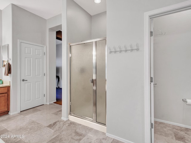 bathroom featuring a stall shower, vanity, and baseboards