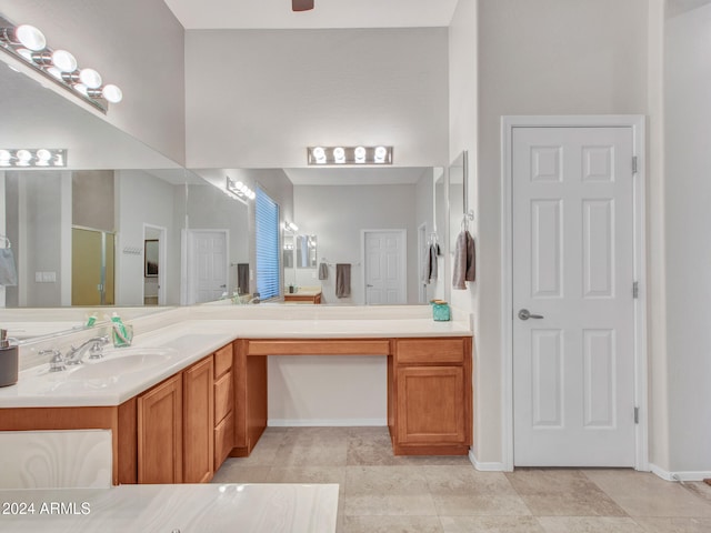 bathroom with tile patterned floors, a shower stall, baseboards, and vanity