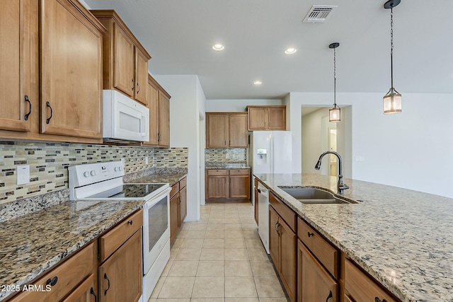 27413 W Tonopah Dr, Buckeye, AZ 85396 - kitchen featuring white appliances, a sink, brown cabinets, backsplash, and dark stone countertops