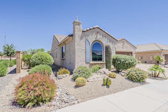 27413 W Tonopah Dr, Buckeye, AZ 85396 - view of property exterior featuring a garage, stucco siding, a tile roof, and a chimney