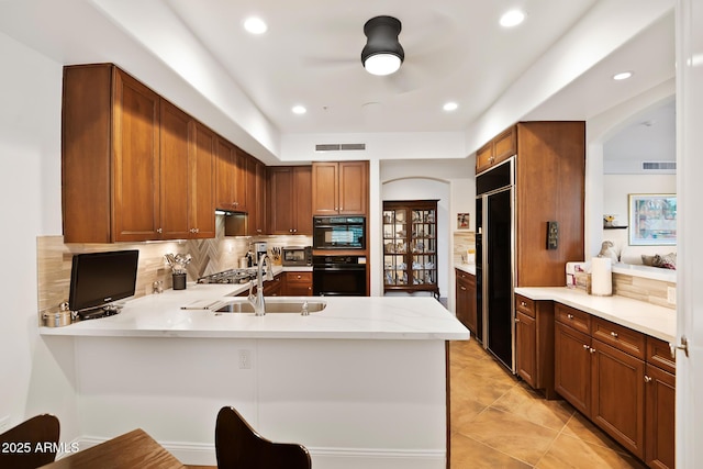 3801 N Goldwater Blvd Unit 201, Scottsdale, AZ 85251 - kitchen with a sink, built in refrigerator, decorative backsplash, a ceiling fan, and a peninsula
