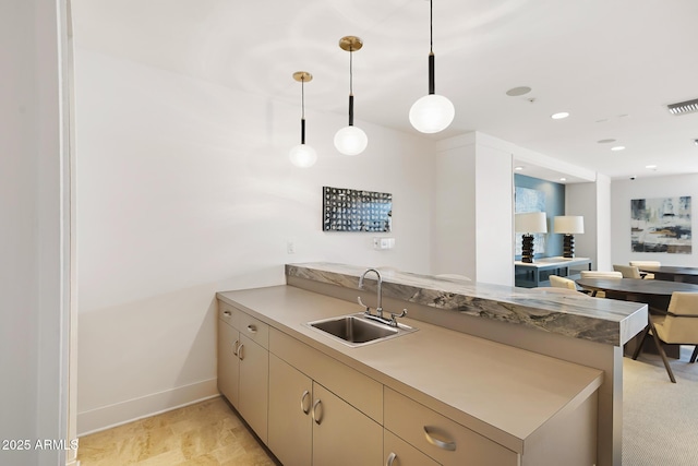 3801 N Goldwater Blvd Unit 201, Scottsdale, AZ 85251 - kitchen featuring a sink, a peninsula, decorative light fixtures, baseboards, and light countertops
