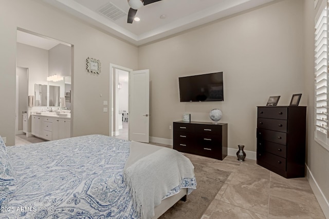 bedroom with baseboards, visible vents, ensuite bathroom, and a sink
