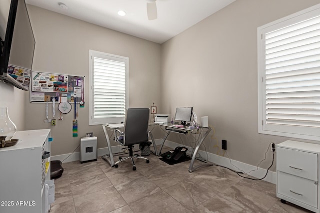 home office with a ceiling fan and baseboards