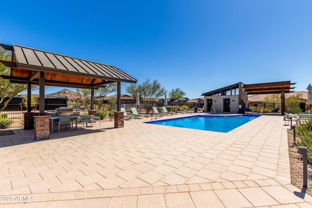 community pool featuring a patio and fence