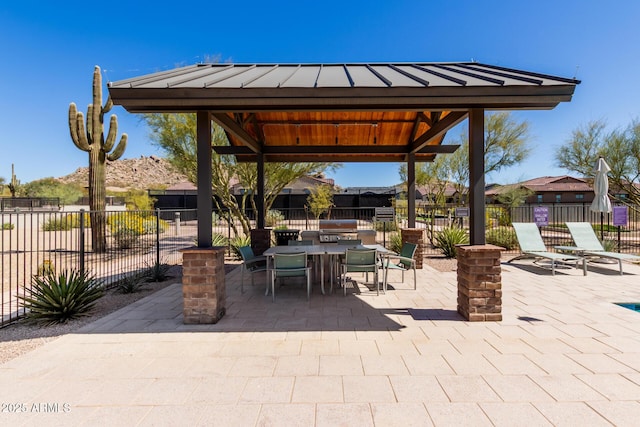 view of patio with outdoor dining space, a gazebo, and fence