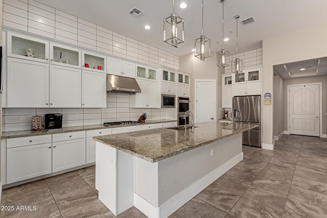 kitchen with under cabinet range hood, visible vents, stainless steel appliances, and a sink