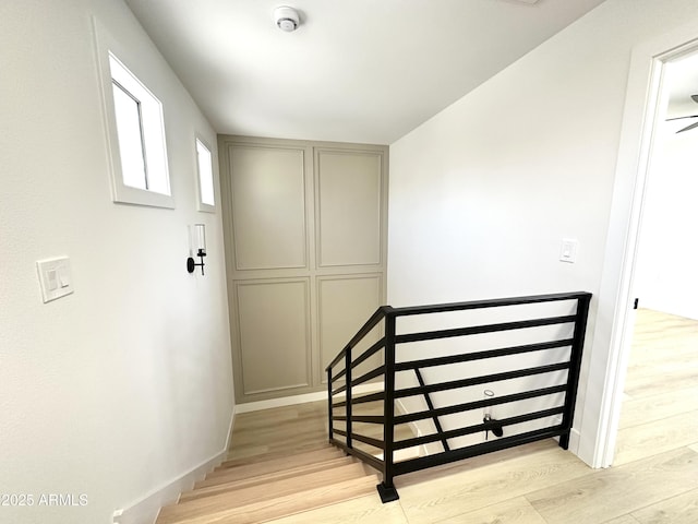 staircase with wood finished floors and baseboards