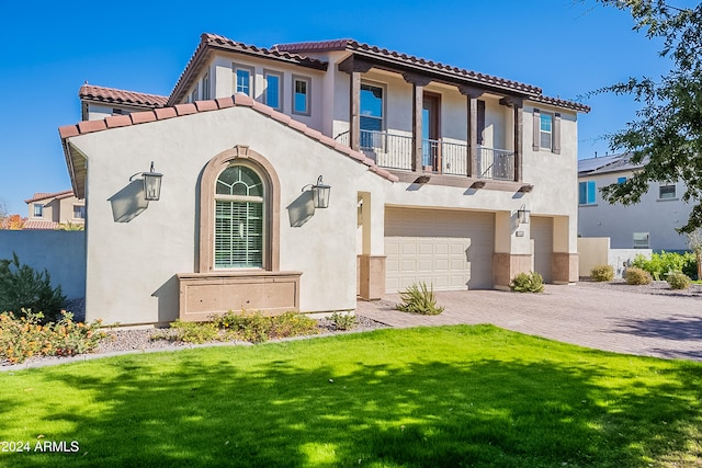 mediterranean / spanish home with a balcony, a front lawn, and a garage