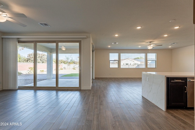 interior space with plenty of natural light, ceiling fan, and dark hardwood / wood-style flooring