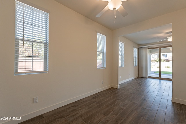 empty room with a wealth of natural light, dark hardwood / wood-style flooring, and ceiling fan