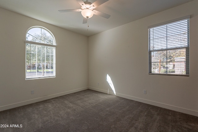 empty room featuring dark colored carpet and ceiling fan