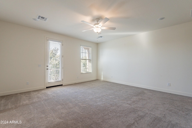 empty room with ceiling fan and light colored carpet