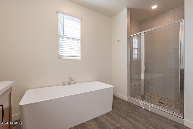 bathroom featuring independent shower and bath, vanity, and wood-type flooring