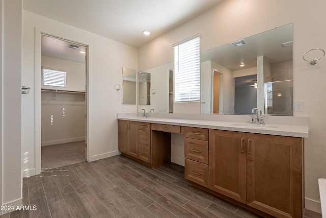 bathroom with hardwood / wood-style floors, vanity, and a shower with door