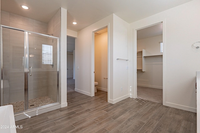 bathroom with a shower with door, wood-type flooring, and toilet