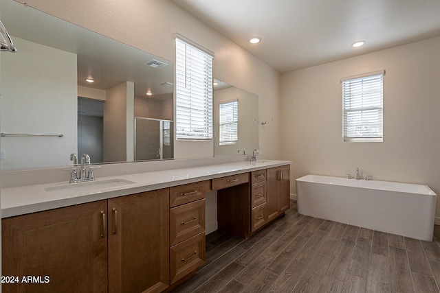 bathroom with hardwood / wood-style floors, vanity, plus walk in shower, and a wealth of natural light