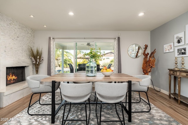 dining room featuring wood-type flooring and a high end fireplace