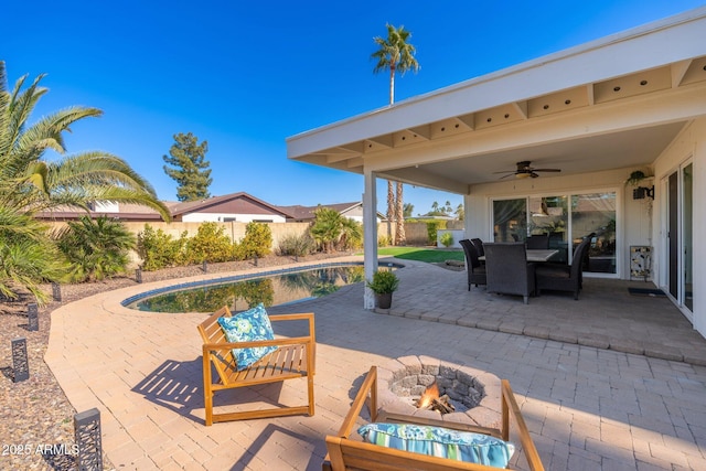 view of patio / terrace with ceiling fan and a fire pit