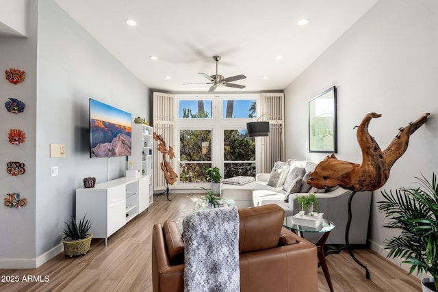 living room featuring ceiling fan and light hardwood / wood-style flooring