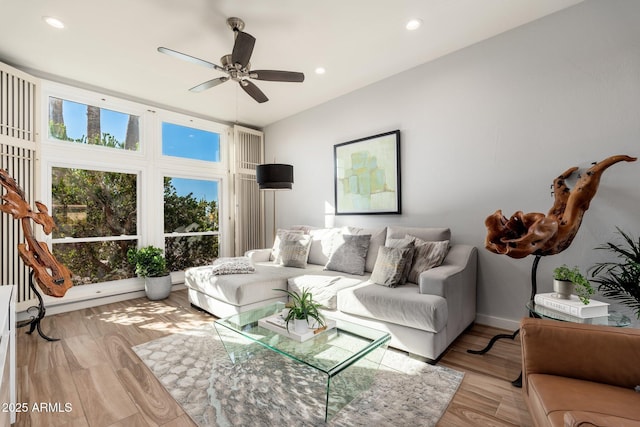 living room featuring ceiling fan and light hardwood / wood-style flooring