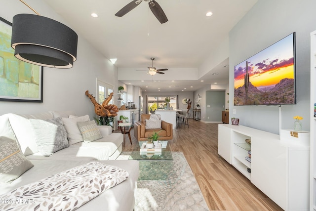 living room with ceiling fan and light wood-type flooring