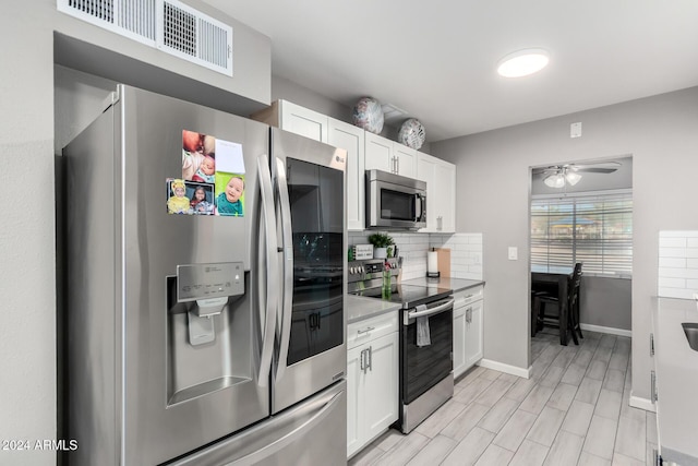 kitchen with ceiling fan, white cabinetry, backsplash, and appliances with stainless steel finishes