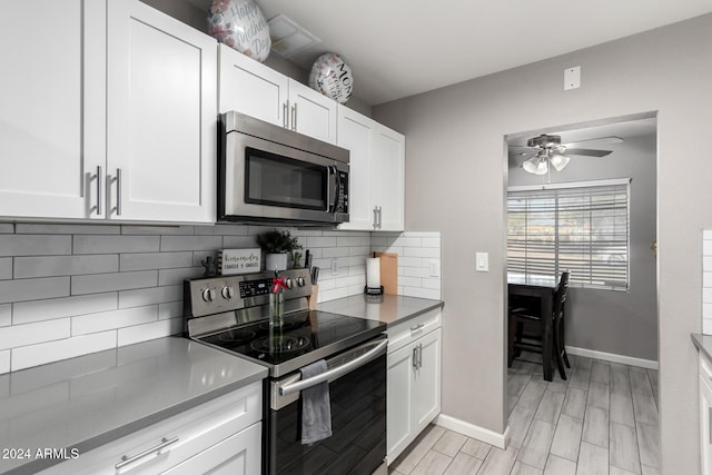 kitchen with appliances with stainless steel finishes, tasteful backsplash, white cabinetry, and ceiling fan