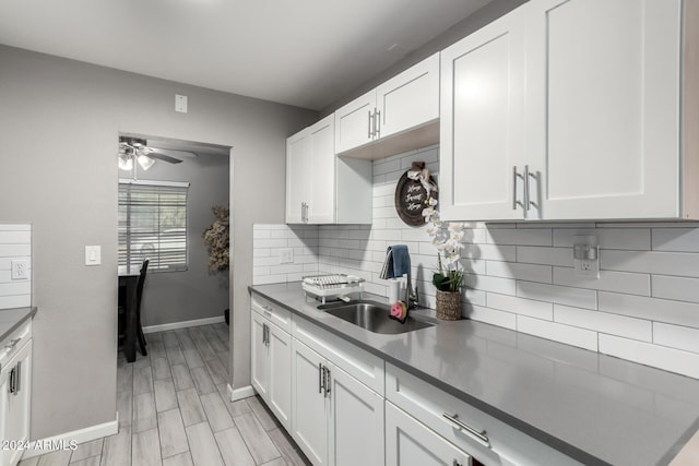 kitchen with white cabinets, tasteful backsplash, ceiling fan, and sink