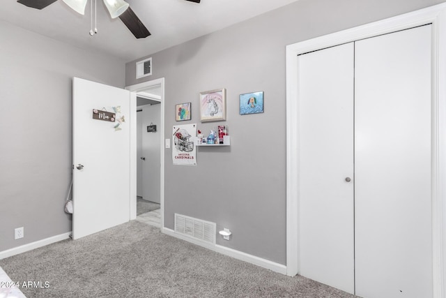 unfurnished bedroom with ceiling fan, light carpet, and a closet