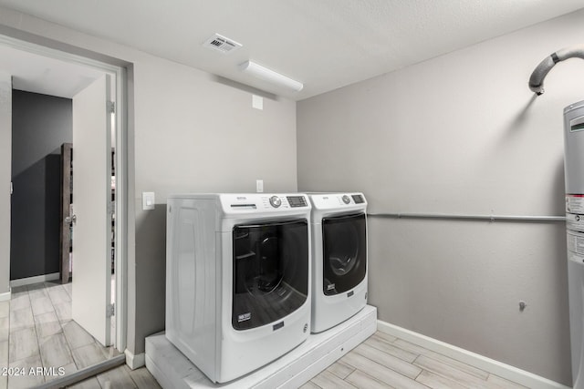 clothes washing area with independent washer and dryer and light hardwood / wood-style flooring