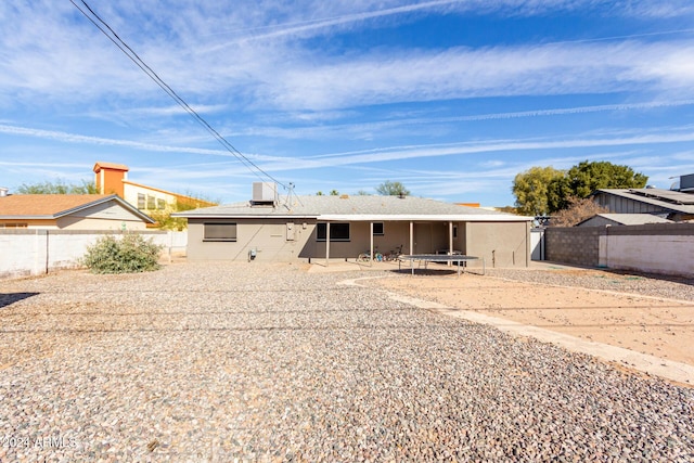 back of property featuring central AC unit and a trampoline