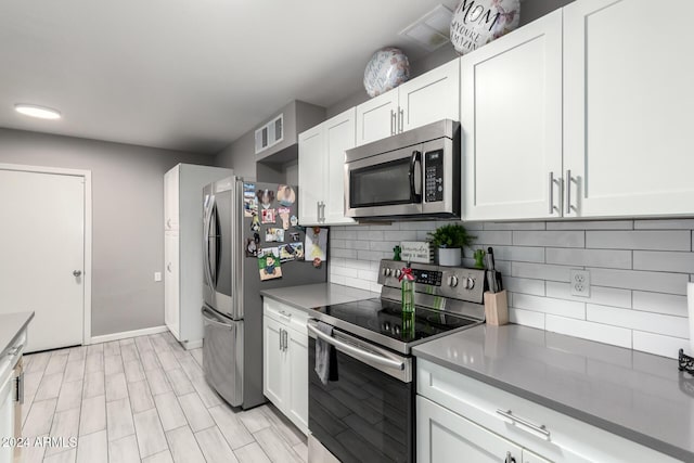 kitchen featuring backsplash, white cabinetry, and stainless steel appliances