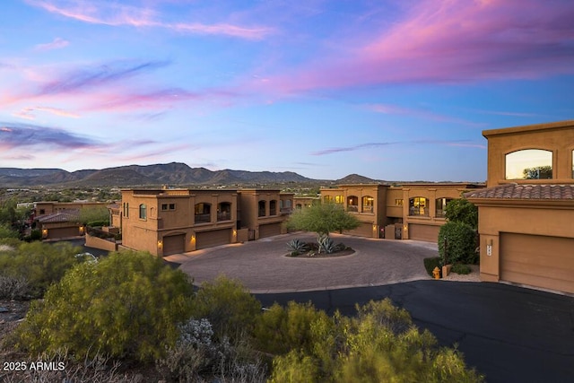 7199 E Ridgeview Pl Unit 221, Carefree, AZ 85377 - view of front of property with stucco siding, an attached garage, a mountain view, and driveway