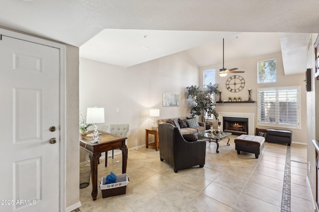 living room featuring lofted ceiling, light tile patterned floors, and ceiling fan