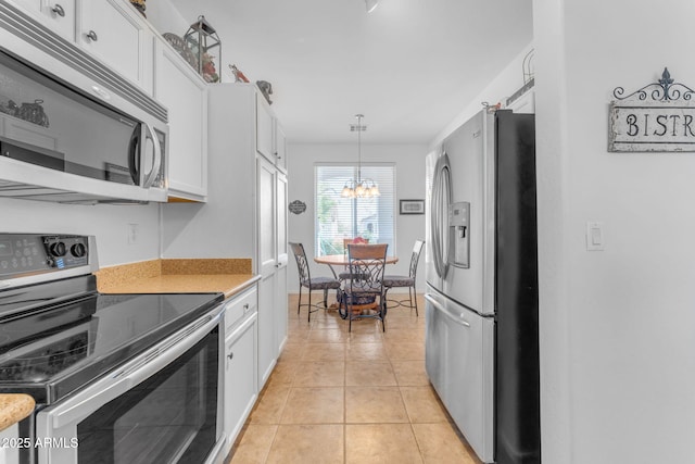 kitchen with white cabinetry, pendant lighting, stainless steel appliances, and light tile patterned flooring