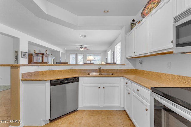 kitchen with white cabinetry, sink, kitchen peninsula, and appliances with stainless steel finishes